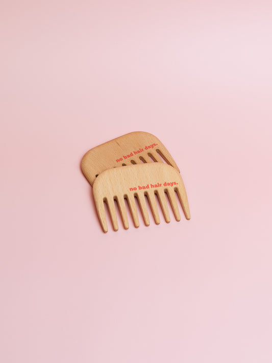 zwei kleine Holzkämme mit breiten Zinken und "no bad hair days" Druck in rot-pink