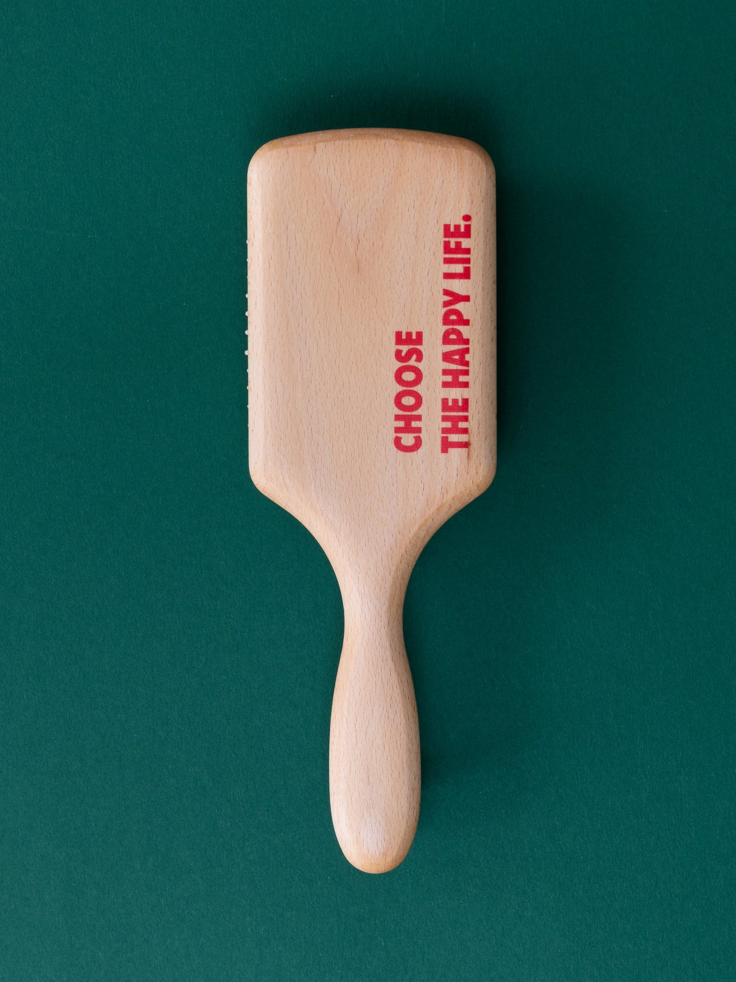 Rückseite der Paddlebrush aus Holz mit "Choose the happy life." Druck in Rot